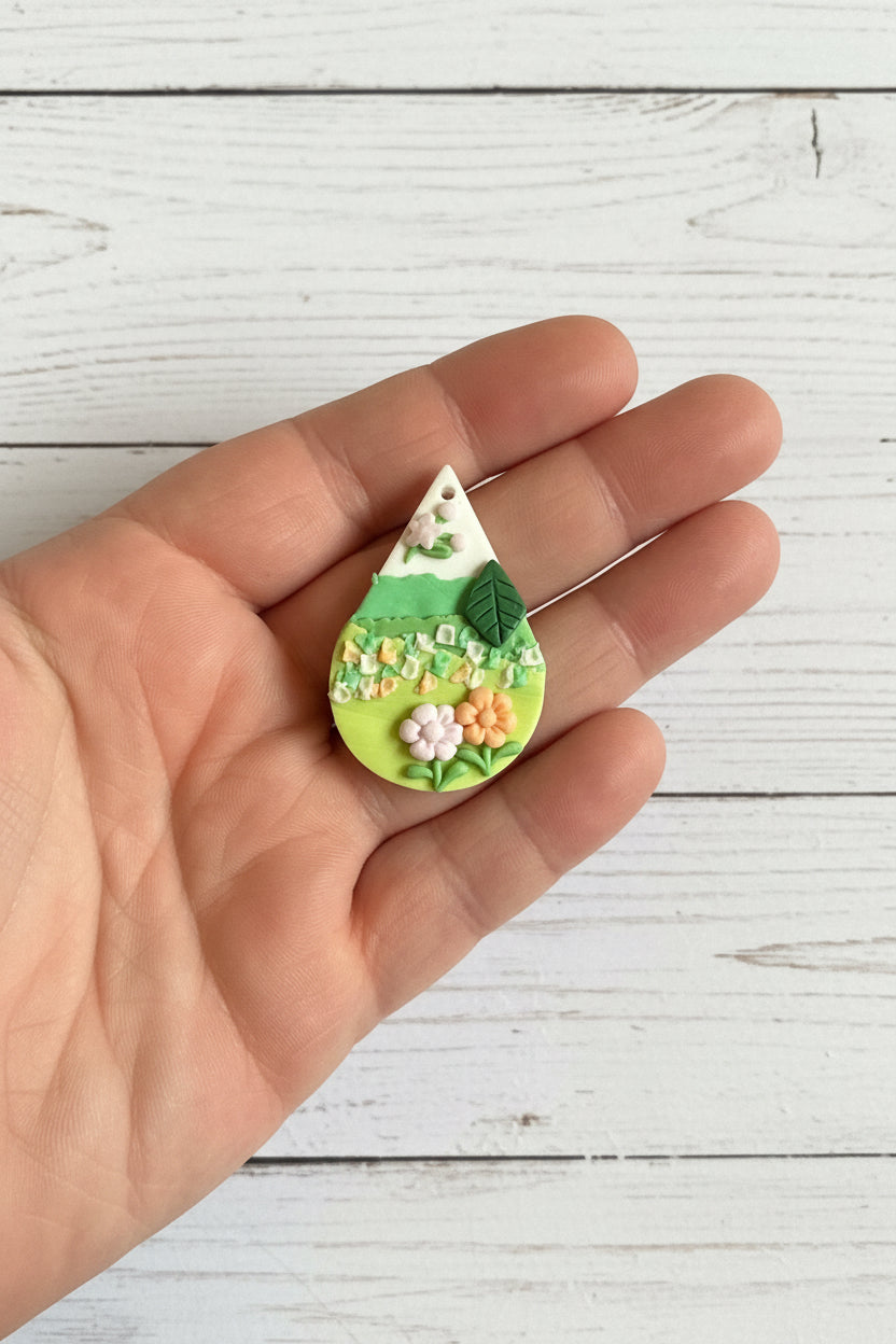 Handmade polymer clay floral pendant, lightweight and handcrafted with intricate 3D flower and leaf details, suitable for necklaces, earrings, and bag charms