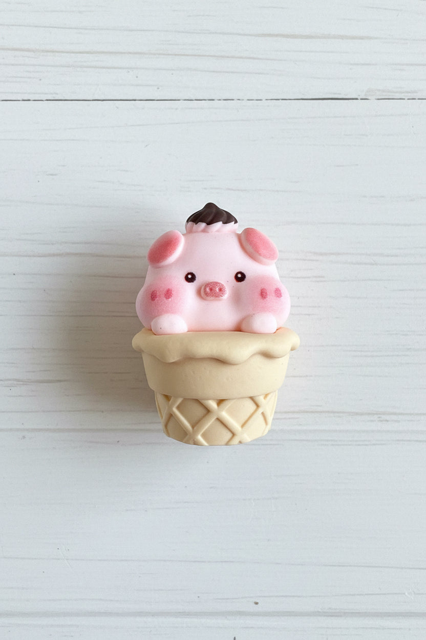 Cute pig figurine balanced on a chocolate macaron craft embellishment - Kingyscrafts