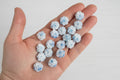 14mm white and blue soft rose flower embellishments held in a hand to show size, pack of 50 for crafts