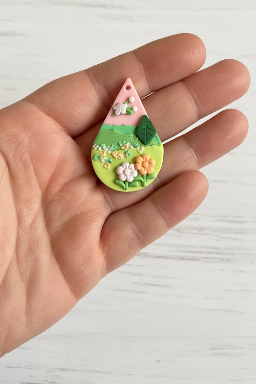 Handmade polymer clay floral pendant, lightweight and handcrafted with intricate 3D flower and leaf details, suitable for necklaces, earrings, and bag charms