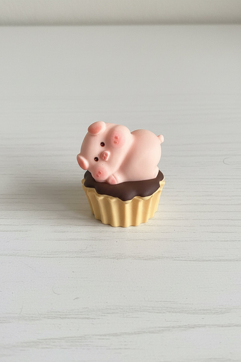 Pink pig figurine sitting on a chocolate tart craft embellishment - Kingyscrafts