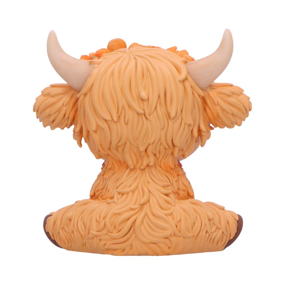 Moo Crew Marigold orange cow figurine with a flower crown and bell collar, displayed among autumn flowers.