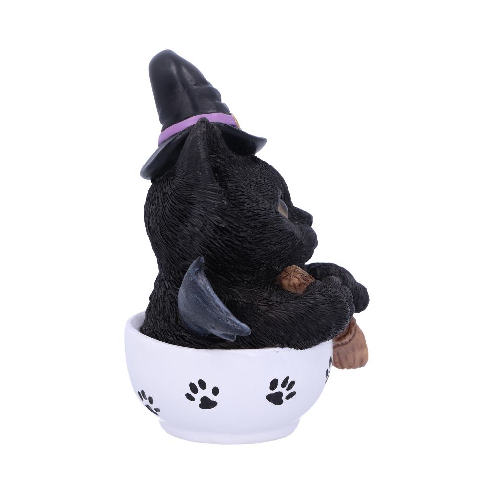 Kit-tea black cat figurine wearing a witch’s hat with bat wings, holding a broomstick in a white paw-print teacup.