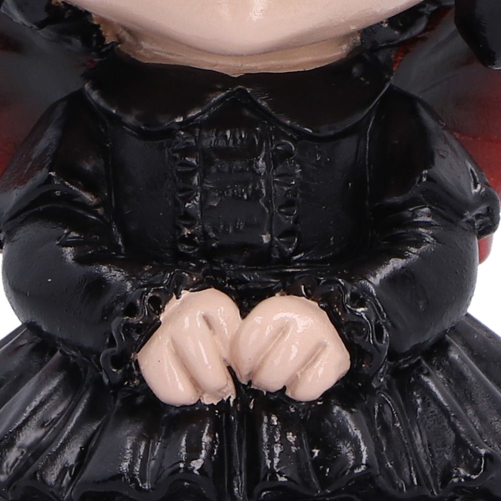 Spirit Fairy Mortina figurine with black hair, red eyes and red-accented wings, wearing a black ruffled dress with clasped hands and a frown.