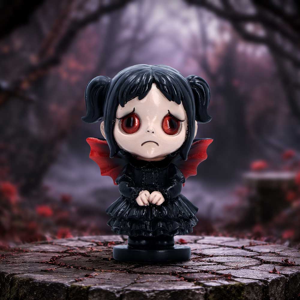 Spirit Fairy Mortina figurine with black hair, red eyes and red-accented wings, wearing a black ruffled dress with clasped hands and a frown.